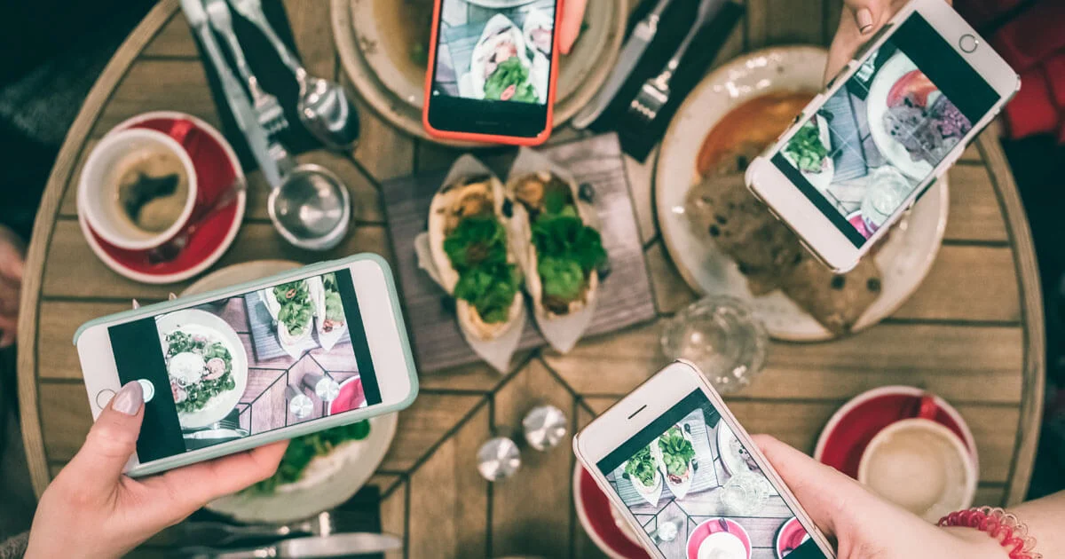 Photo of food on a table, with people taking photos