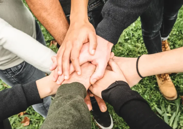 A group of people all putting their hands together