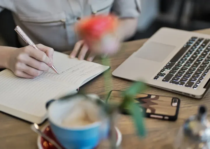 a picture of a person writing in a notebook to plan thier content curation