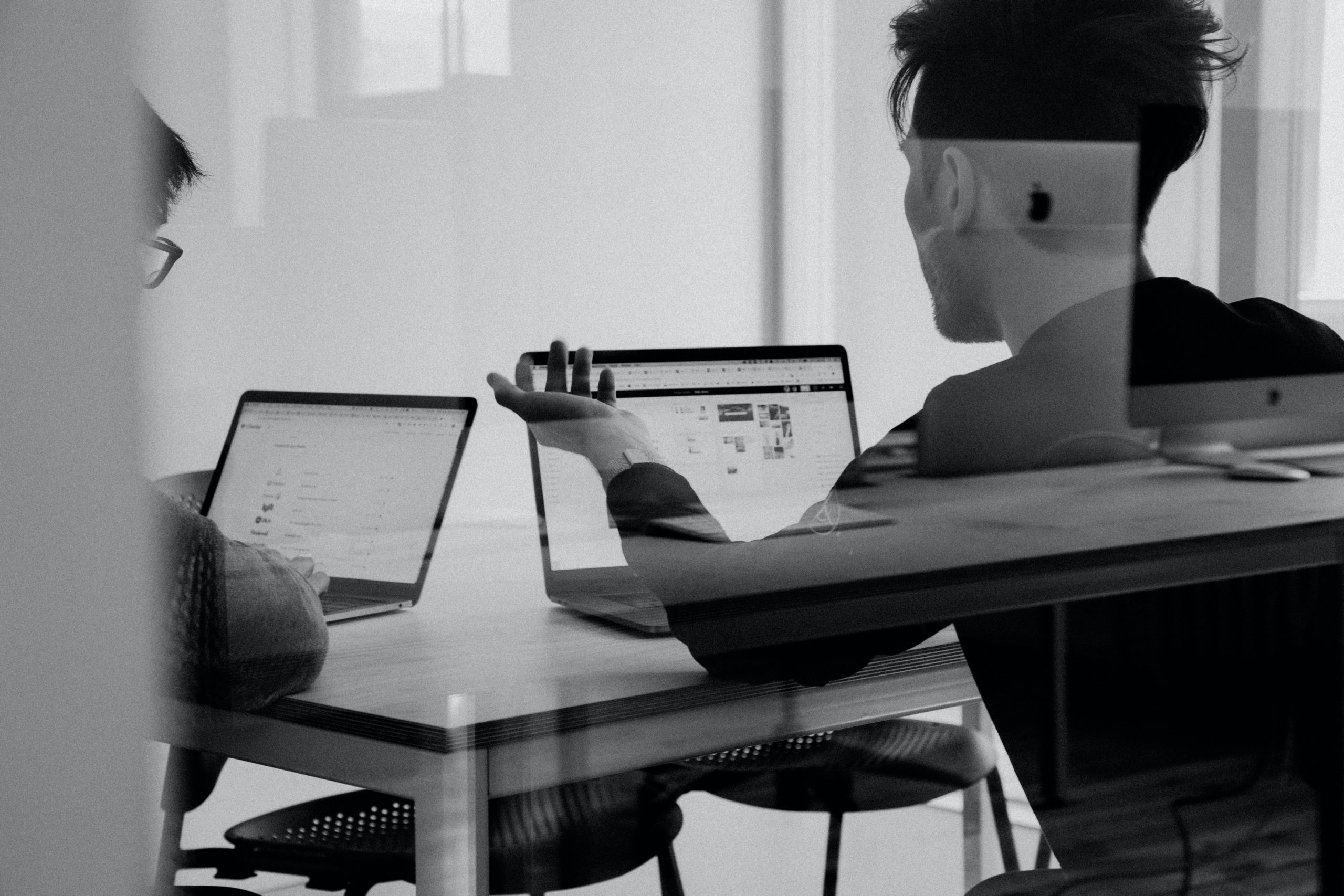 image showing two peope in a discussion whilst using laptops