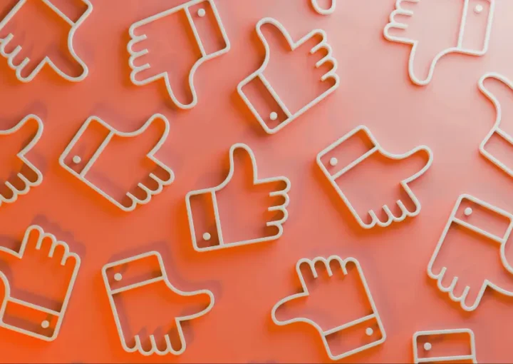 photo shows a bunch of thumbs up emojis in a pattern on an orange background