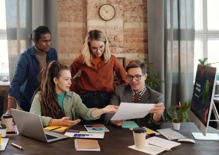 a group of people around a desk looking at a marketing funnel diagram