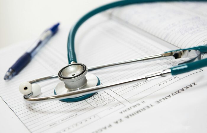 Images shows a stethoscope on a diary with a pen