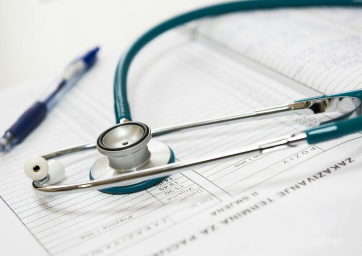Images shows a stethoscope on a diary with a pen